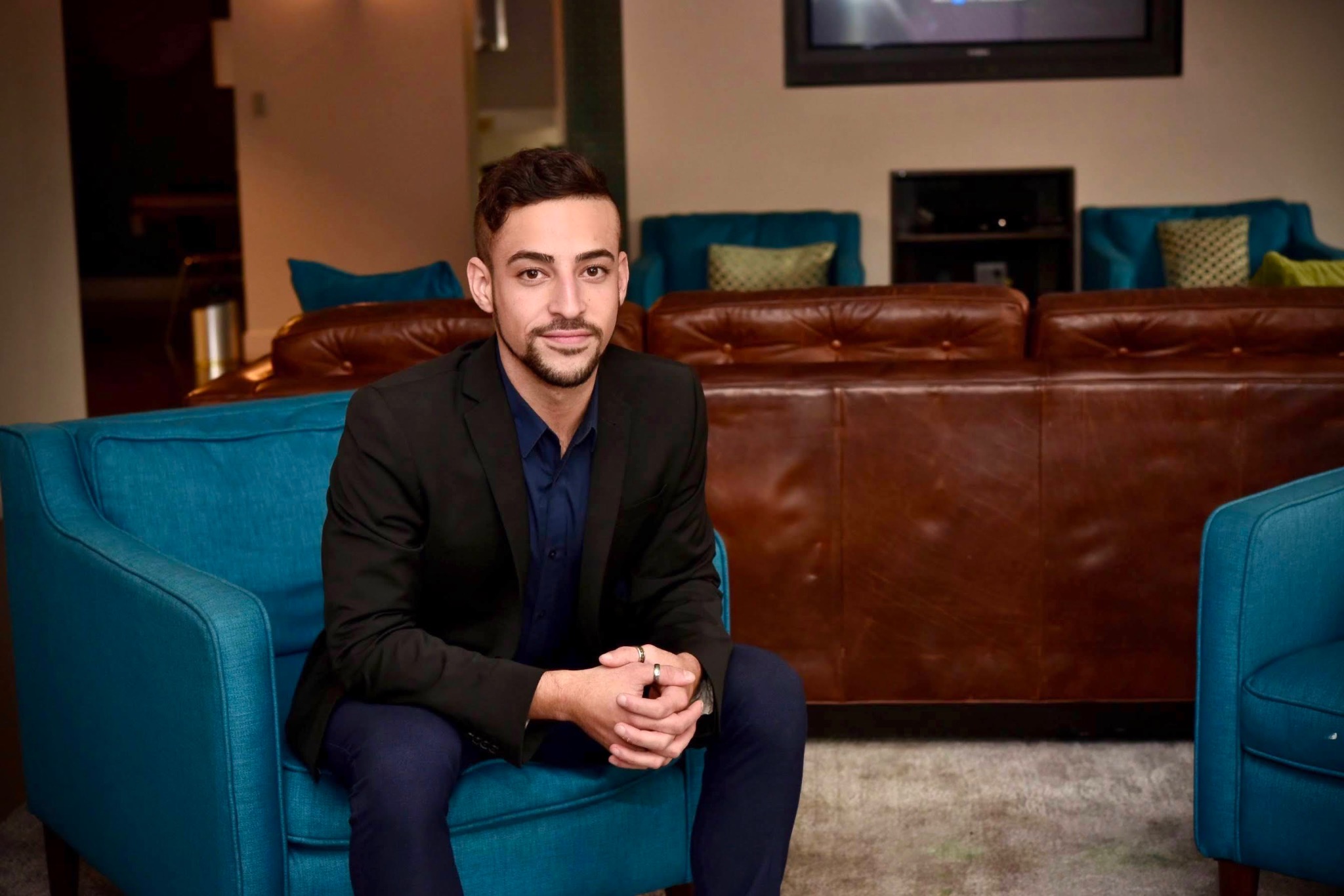 Ryan M. Colon seated in a modern lounge